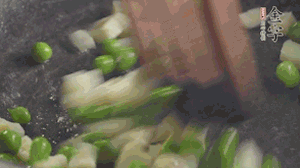 鍋中油7成熱時(shí)，入青豆、筍丁翻炒，然后加糯米飯加鹽均勻翻炒。