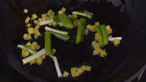 鍋中熱油，依次下姜粒、蔥段、蘆筍炒香。