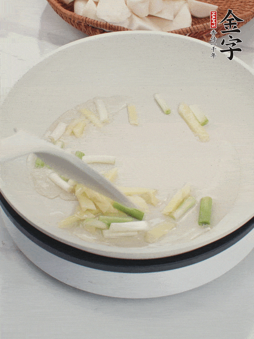 鍋中油五成熱，下蔥白、姜片爆香。