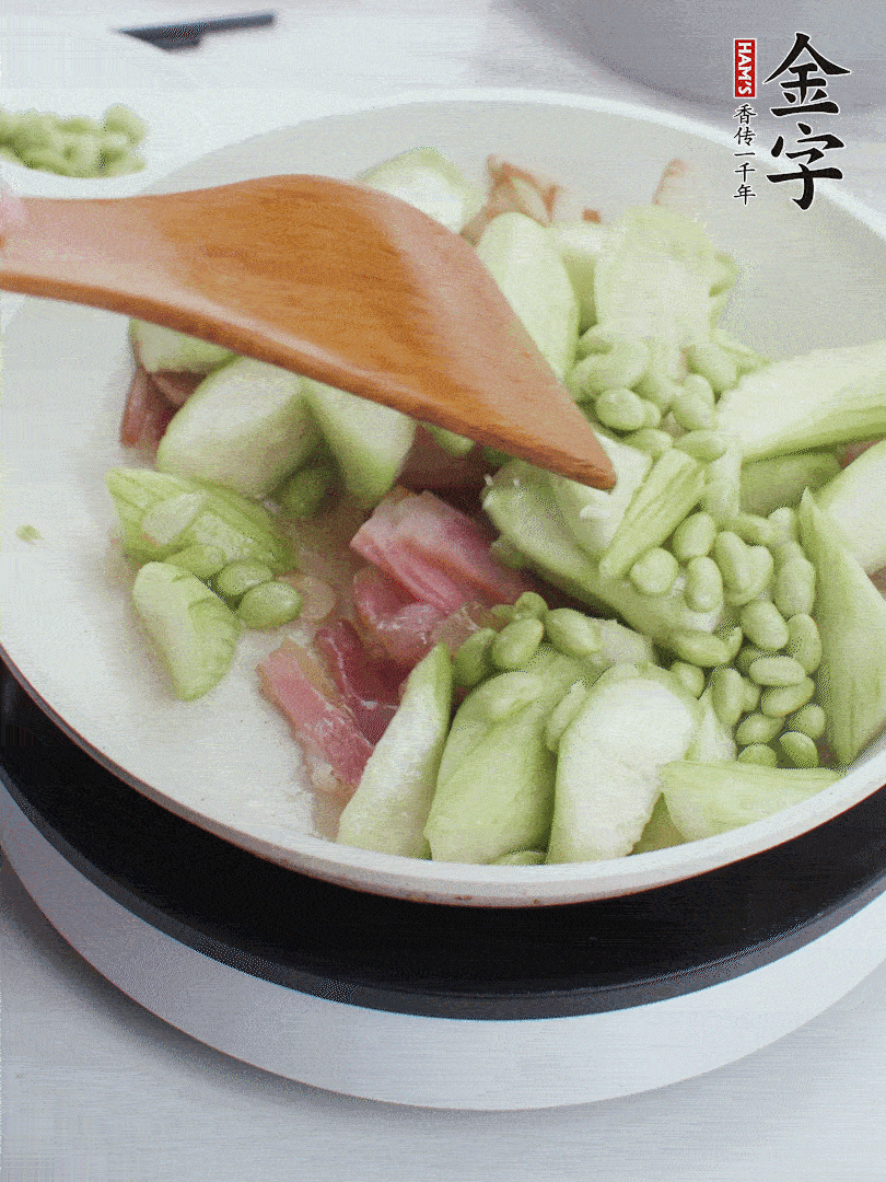 依次下絲瓜、青豆翻炒，炒至絲瓜打蔫縮小。