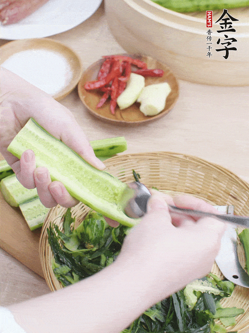 黃瓜削皮，對(duì)半切開(kāi)，勺子挖去內(nèi)瓤，斜刀切片。青蒜斜刀切段。