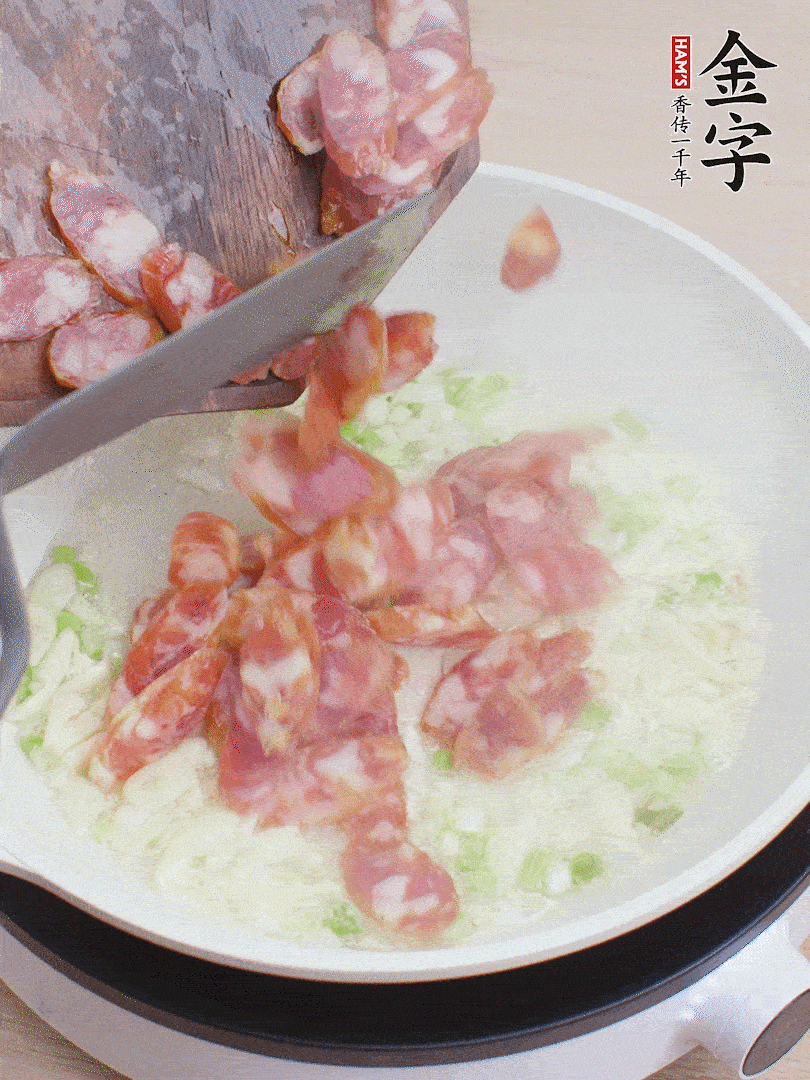 油5成熱，蒜末、蔥白爆香，下香腸炒出香味。