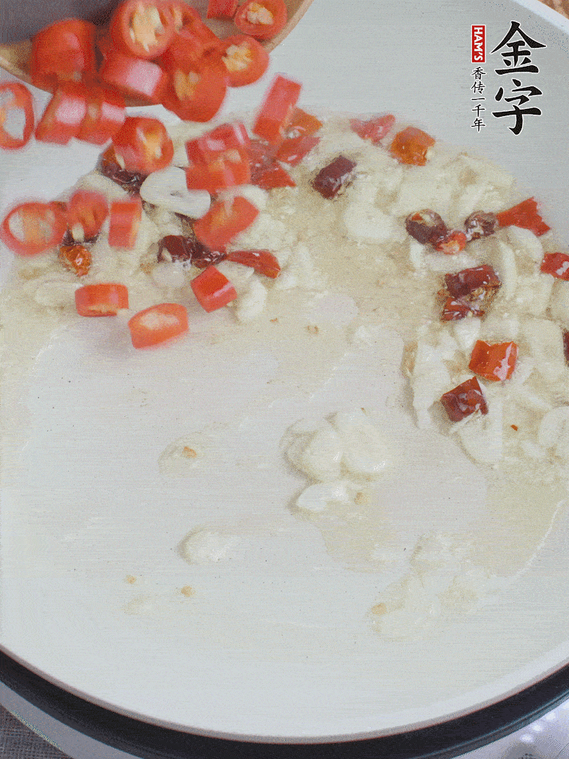 油6成熱，下蒜末、干紅辣椒煸炒，出香味后再放美人椒、香腸。