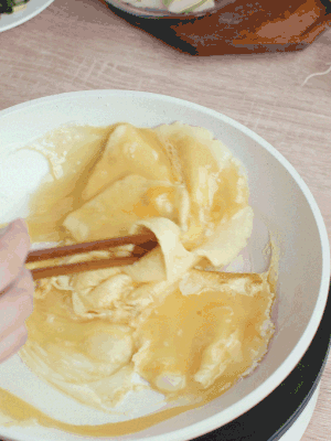 油6成熱時，下雞蛋液，邊緣凝固時翻拌成塊狀。