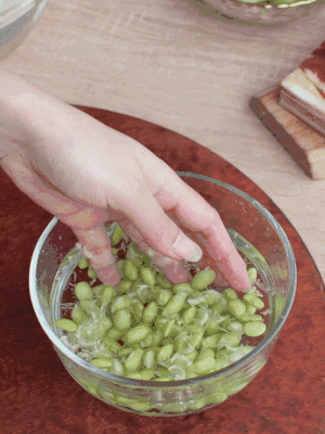 青豆剝殼，搓去外衣。