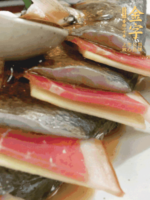 魚肚中塞蔥結(jié)、火腿片，魚身上碼放姜片、火腿片，倒入混合的料汁。