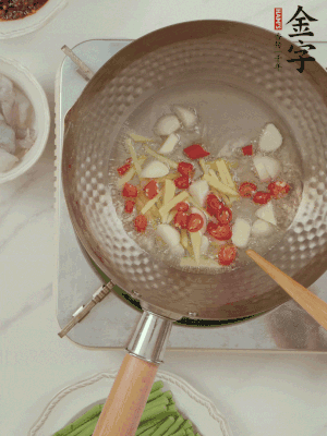 油7成熱時，下大蒜粒、姜絲、小米辣煸香。