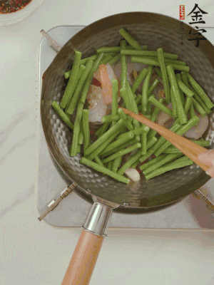 下掰好的缸豆段翻炒，略燜煮。