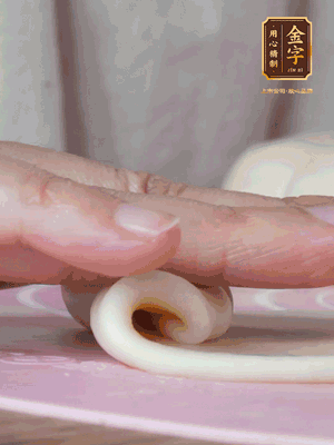 做面劑 油皮按扁，中間包入一個油酥，邊緣收緊捏死。包好的面劑按扁，用搟面杖搟壓成橢圓形。從底部向上卷成筒狀，用保鮮膜蓋好松弛15分鐘，再把筒狀縱向搟壓成長條狀。再卷一次，松弛20分鐘