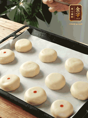 收口向下放在案板上，輕輕將月餅坯按扁，用筷子點紅點做裝飾
