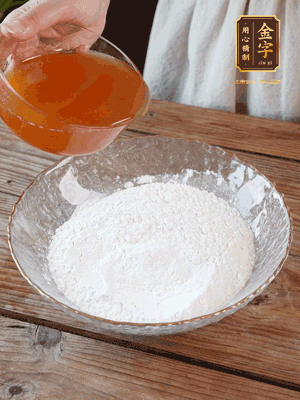 轉(zhuǎn)化糖漿、枧水、花生油攪拌均勻，加入面粉混合，醒發(fā)2小時。捏成23g一個的小球