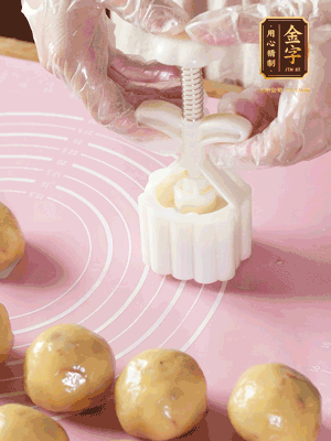 收緊虎口搓圓，裹上一層面粉，放入模具壓一壓