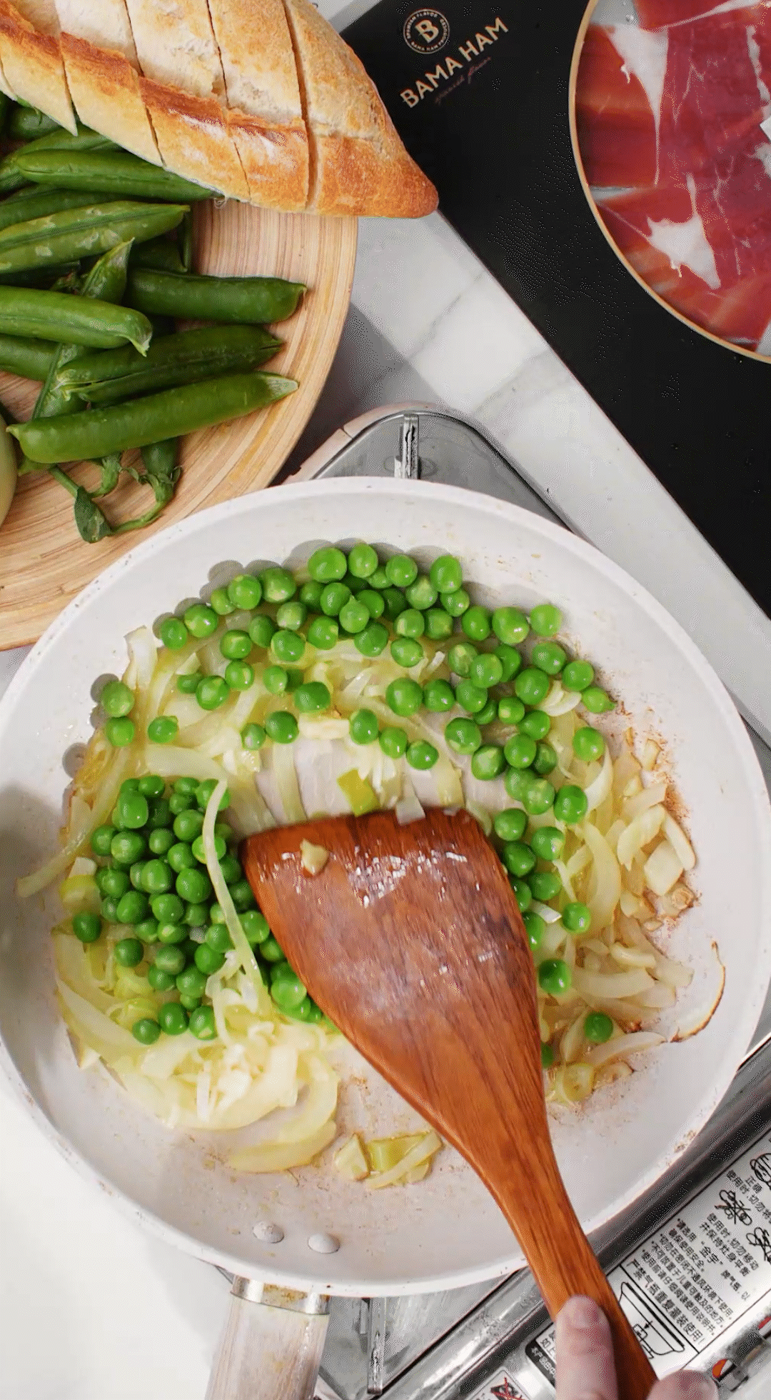 鍋中放入黃油融化，加入洋蔥絲、大蔥蔥白絲、蒜末翻炒變軟出香味。加入剛剛汆燙冰鎮(zhèn)后的豌豆，取出一點(diǎn)點(diǎn)待會擺盤裝飾用。加一點(diǎn)鹽 (和黑胡椒) 調(diào)味。