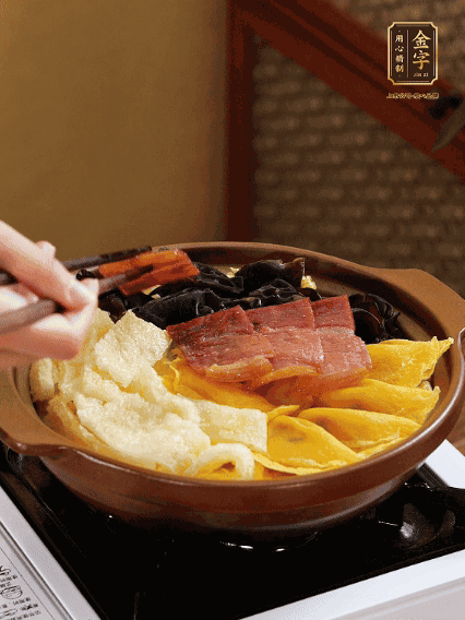 砂鍋底部鋪上娃娃菜，依次擺上肉皮、蛋餃、黑木耳、火腿